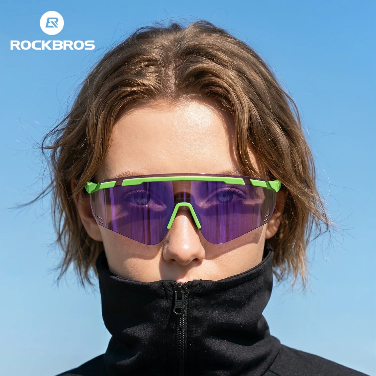 A close-up of a person outdoors wearing ROCKBROS shield-style sunglasses with a bright green frame and purple mirrored lenses, against a clear blue sky. #Color_Purple