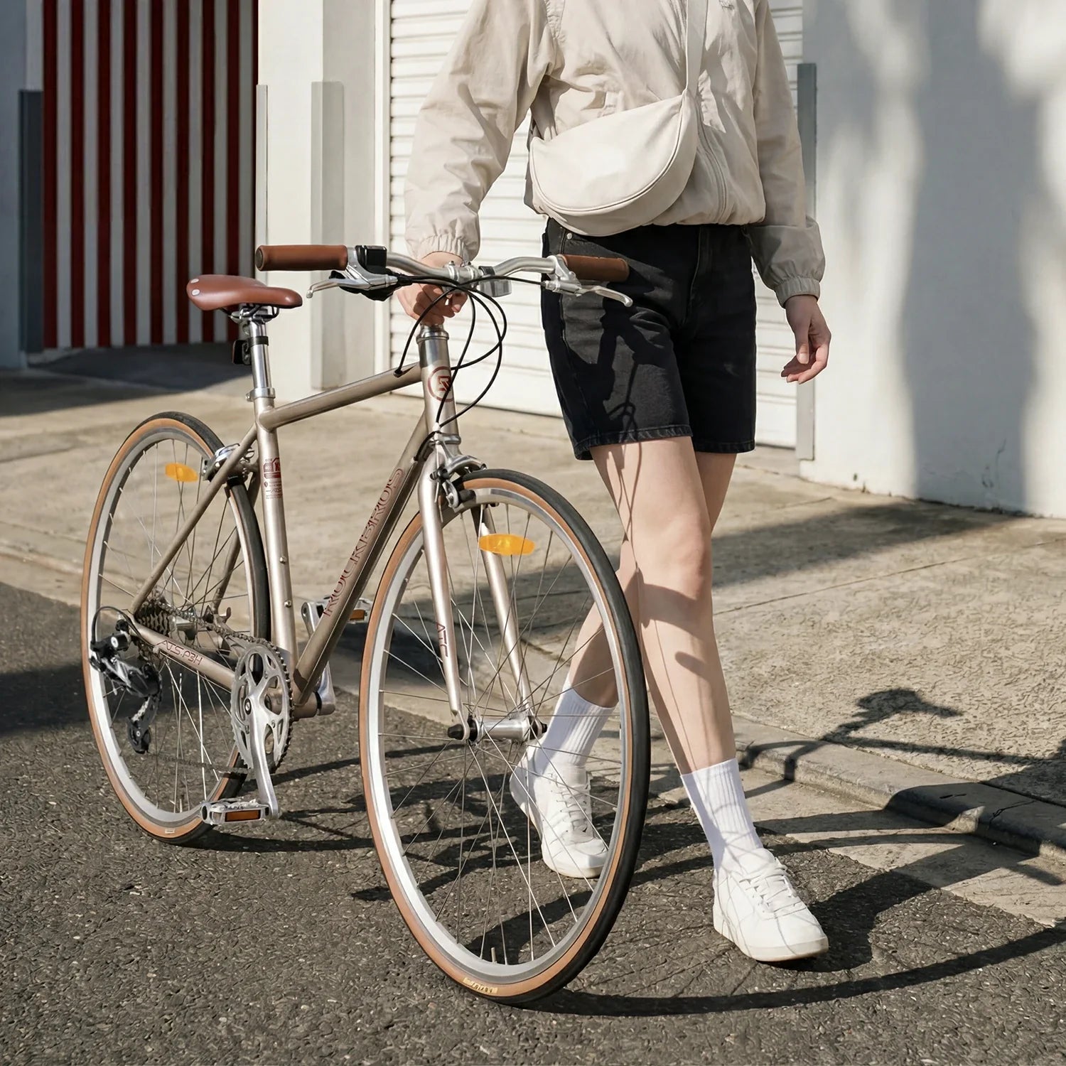 Person standing next to a bicycle on a sidewalk