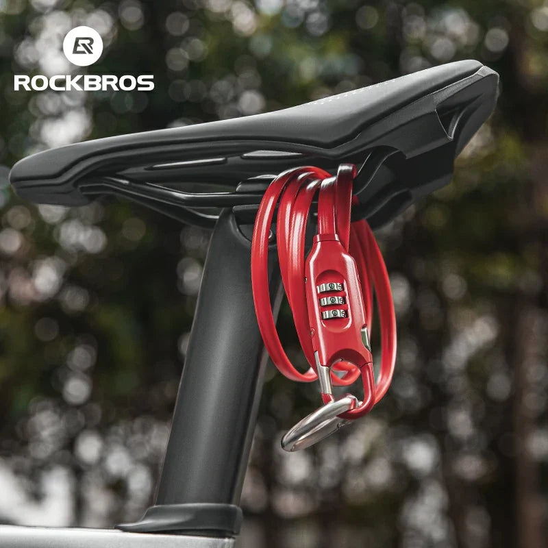 Red bike lock attached to a black bicycle seat with blurred greenery in the background, featuring the RockBros brand.