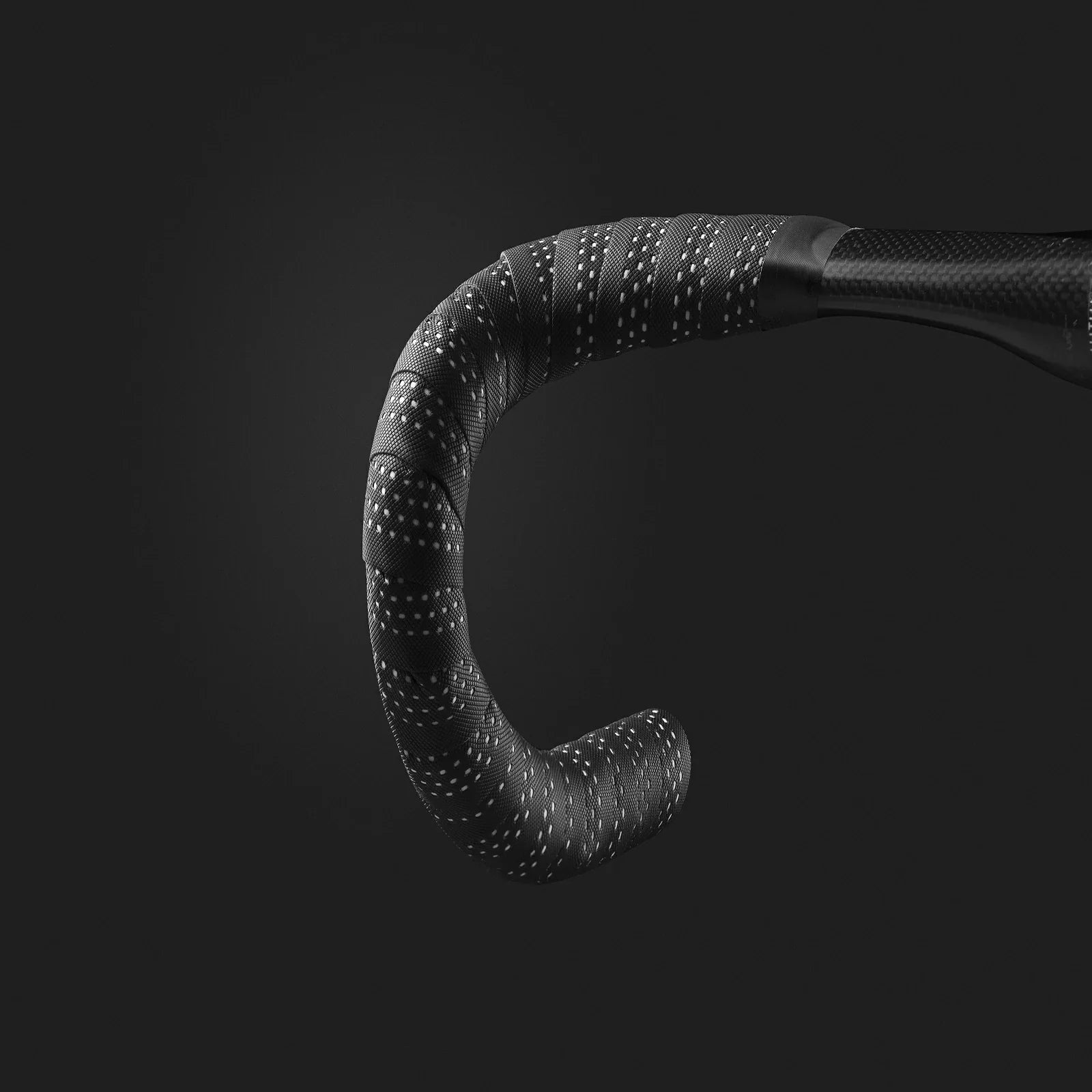 Close-up of a black bicycle drop handlebar wrapped in textured grip tape with small white dotted patterns, shown against a dark gray background. #Color_White