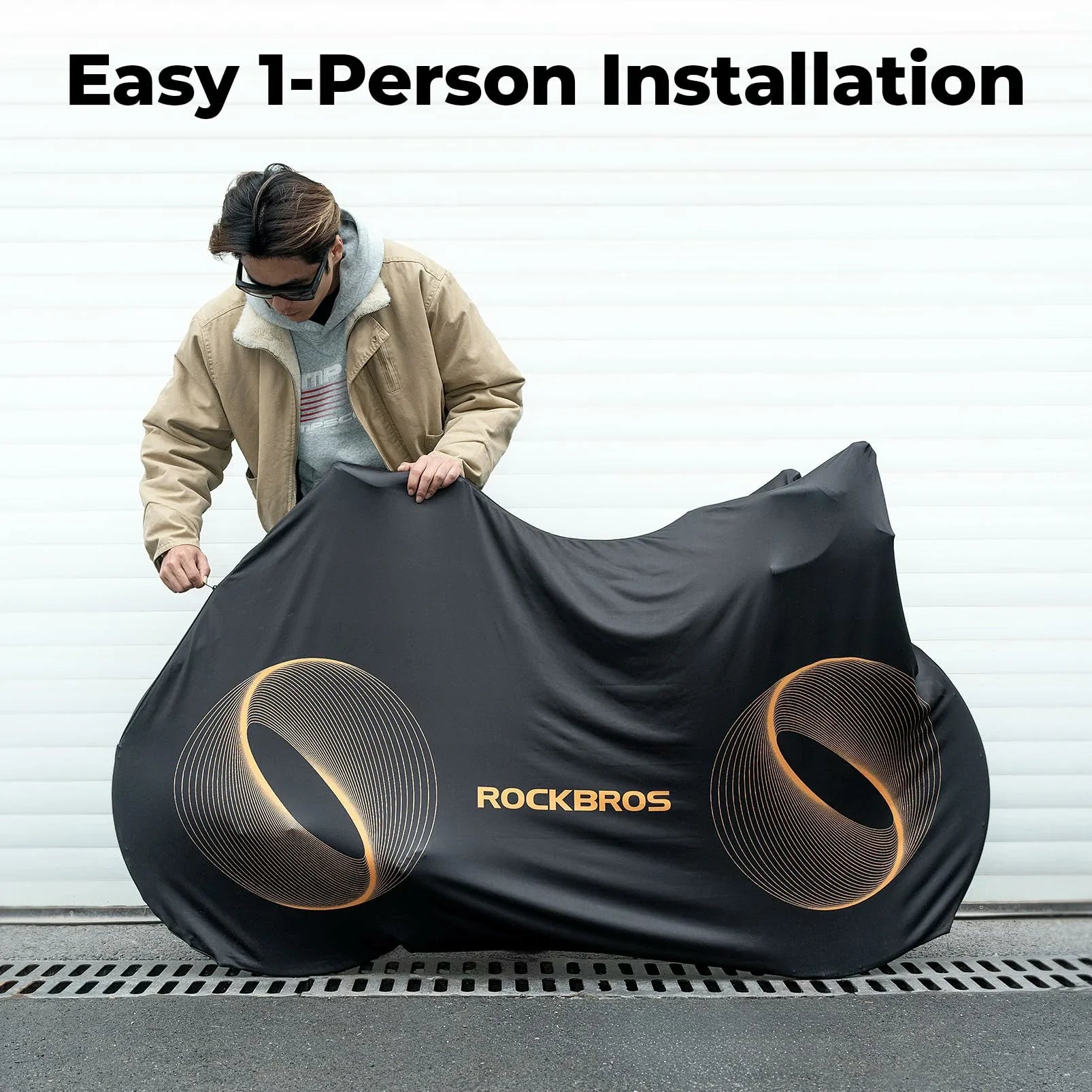 Person lifting a bike cover with 'RockBros' branding and text about easy 1-person installation.