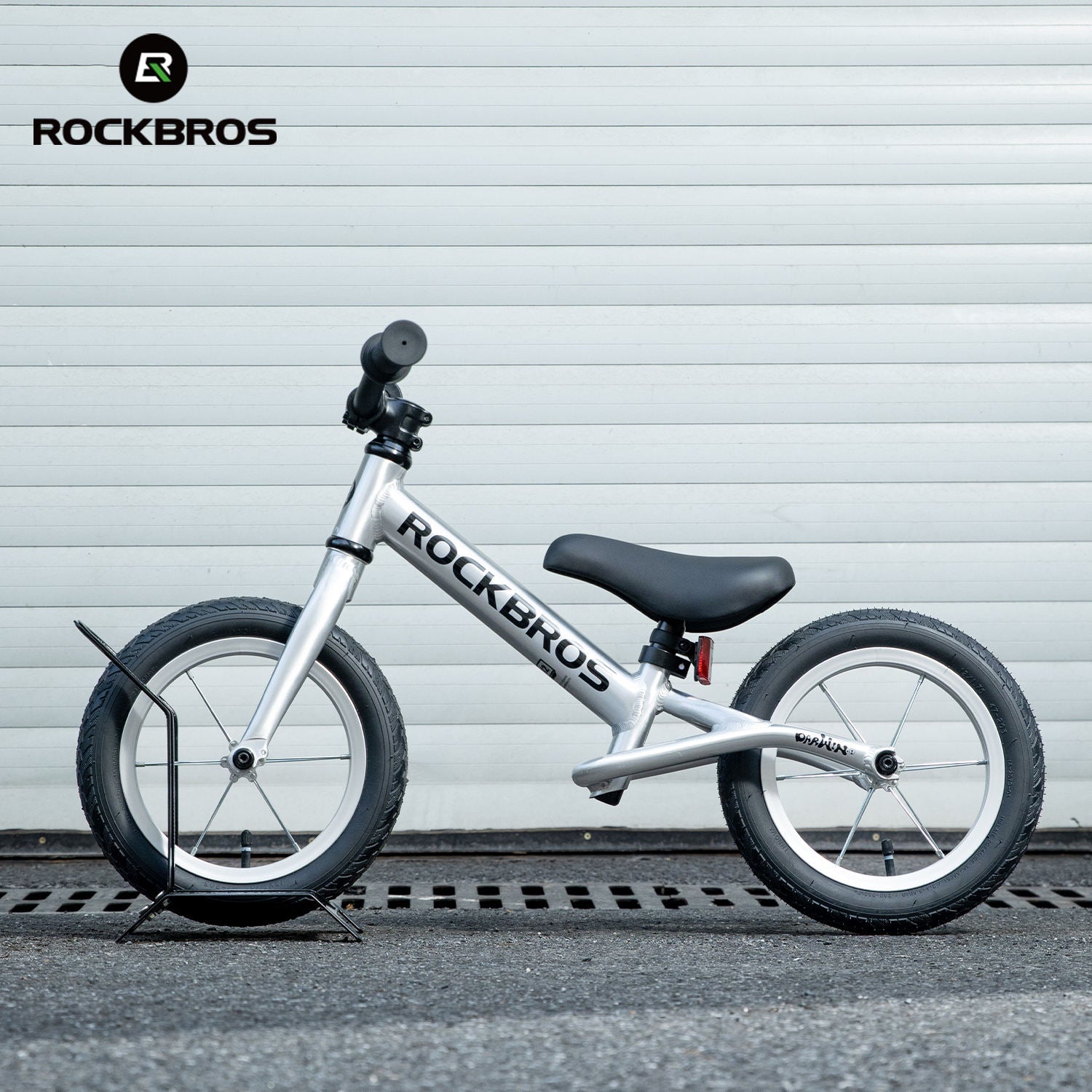 White balance bike with black seat on a gray background, featuring the RockBros brand.
