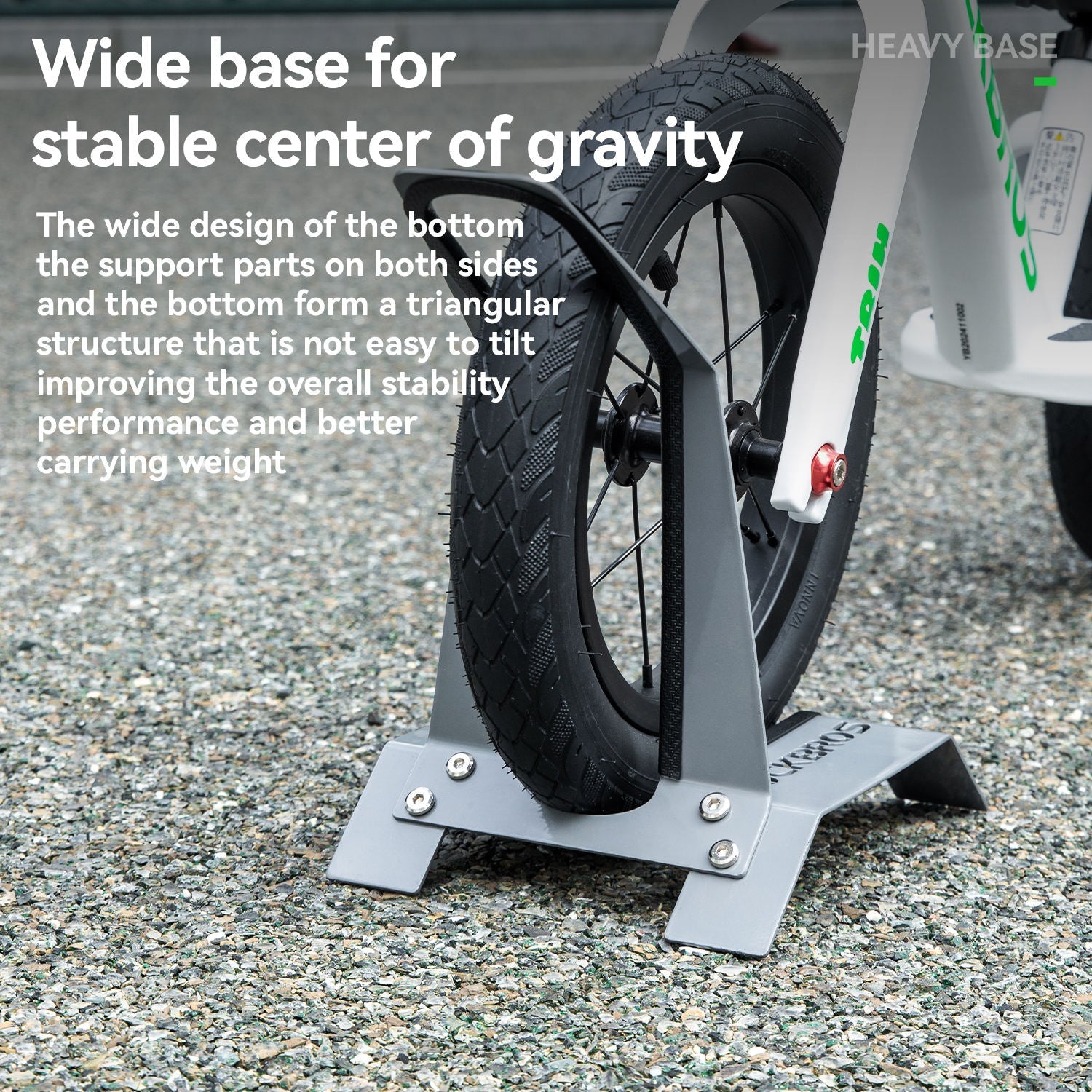 Bicycle stand with wide base on a gravel surface, emphasizing stability and design features.