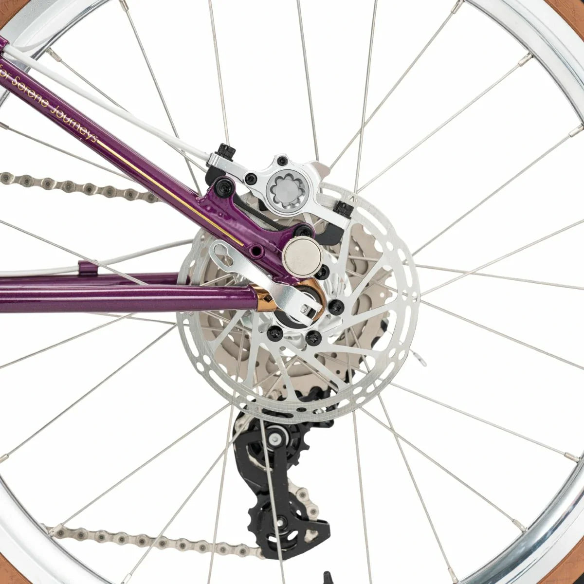 Close-up of a bicycle wheel with purple frame and chain #Color_Purple