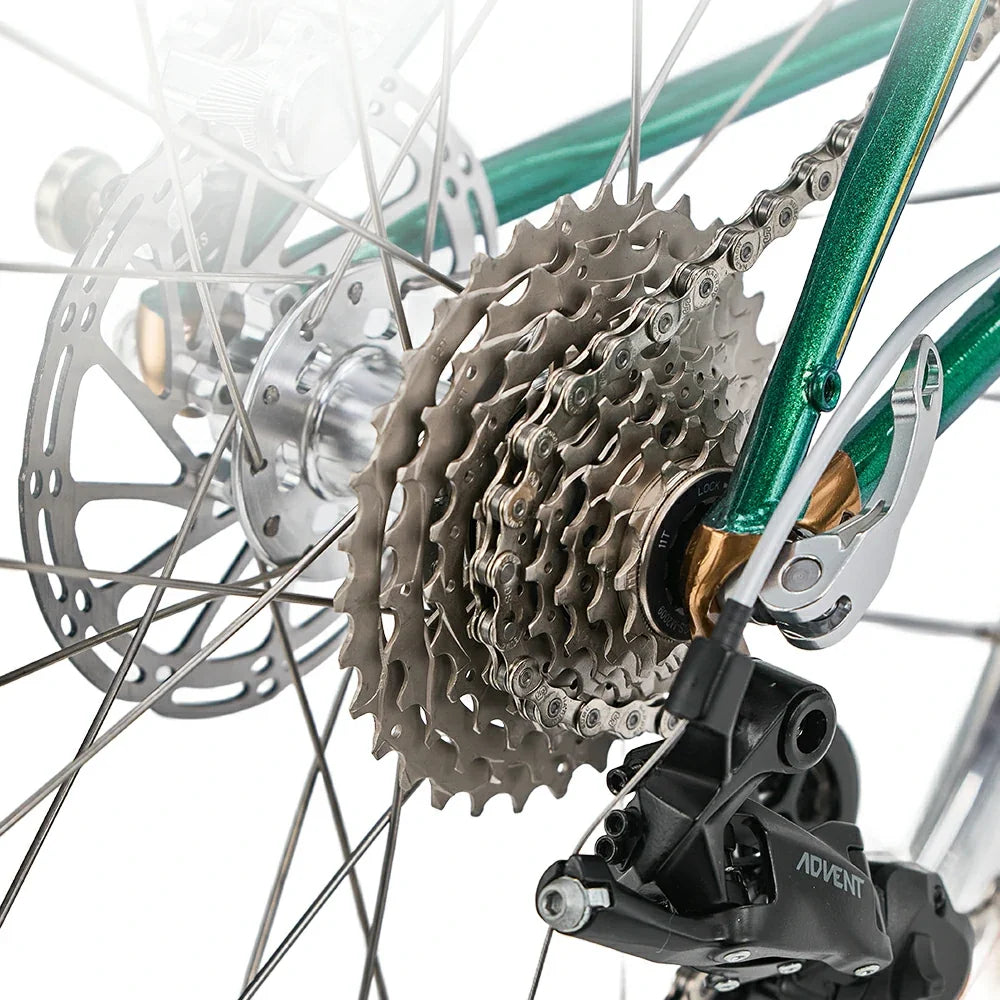 Close-up of a bicycle's gear system with a green frame. #Color_Green