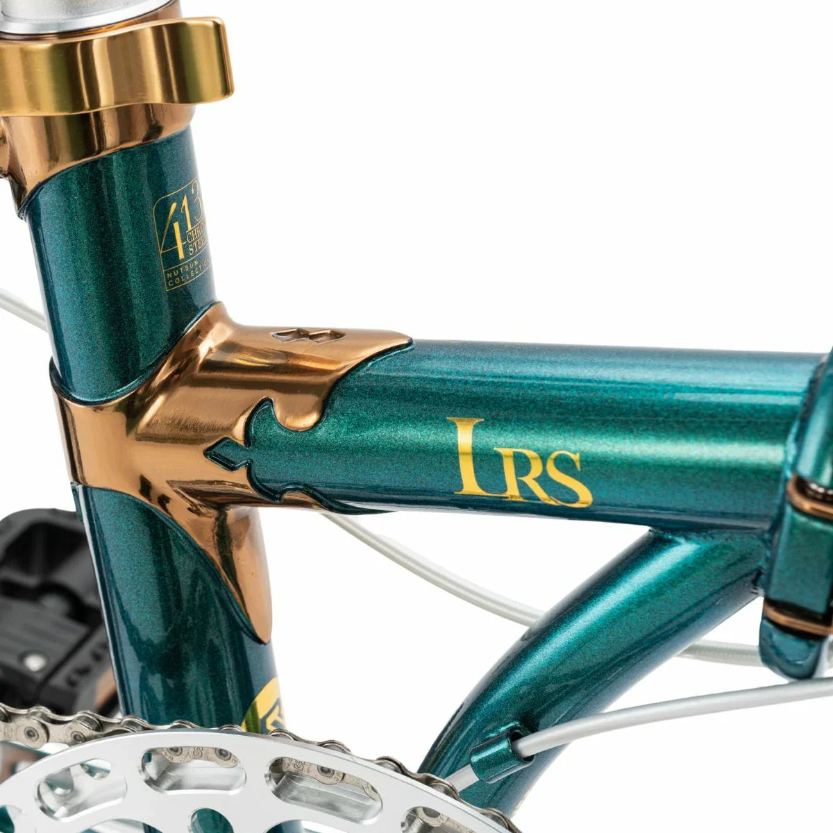 Close-up of a teal and gold bicycle frame with 'LRS' branding. #Color_Green