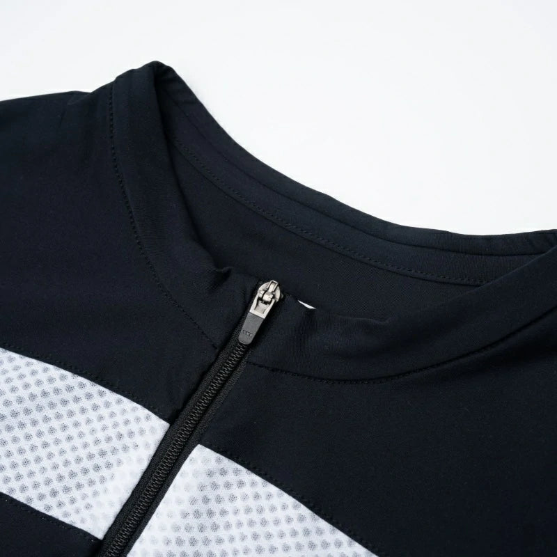 Close-up of a black and white zippered garment on a light gray background