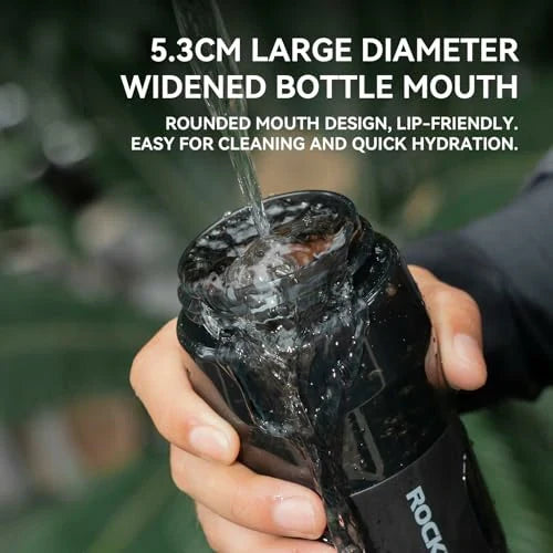 Person holding a black water bottle with text about its features.