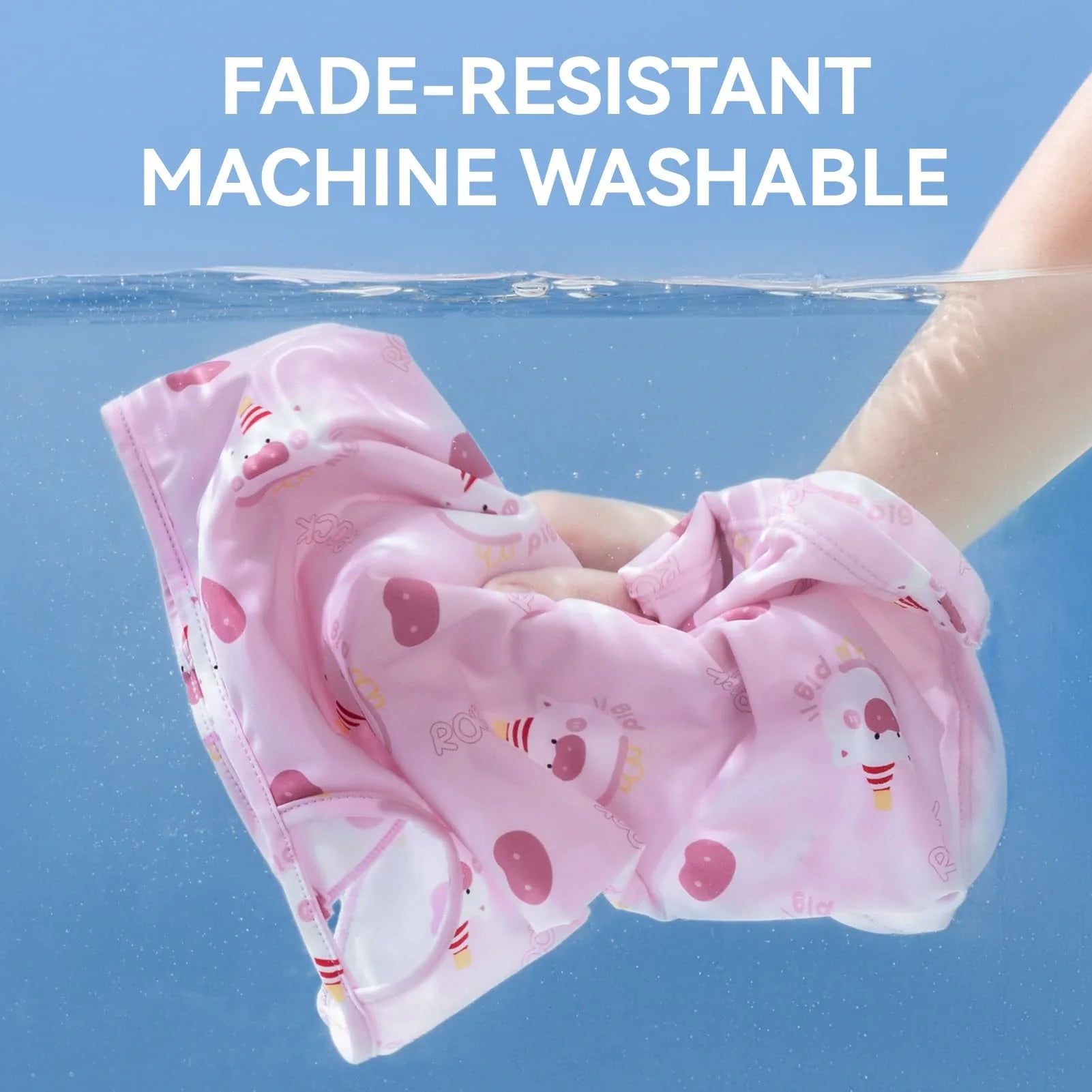 Pink mask with cartoon designs held underwater, text 'Fade-Resistant Machine Washable' above.