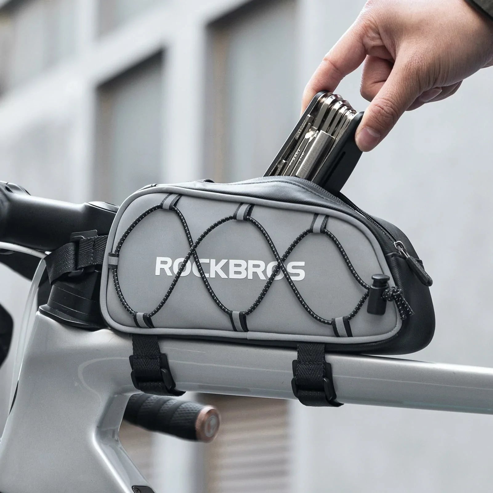 Gray bike frame bag with 'RockBros' branding attached to a bicycle handlebar.  #color_silver