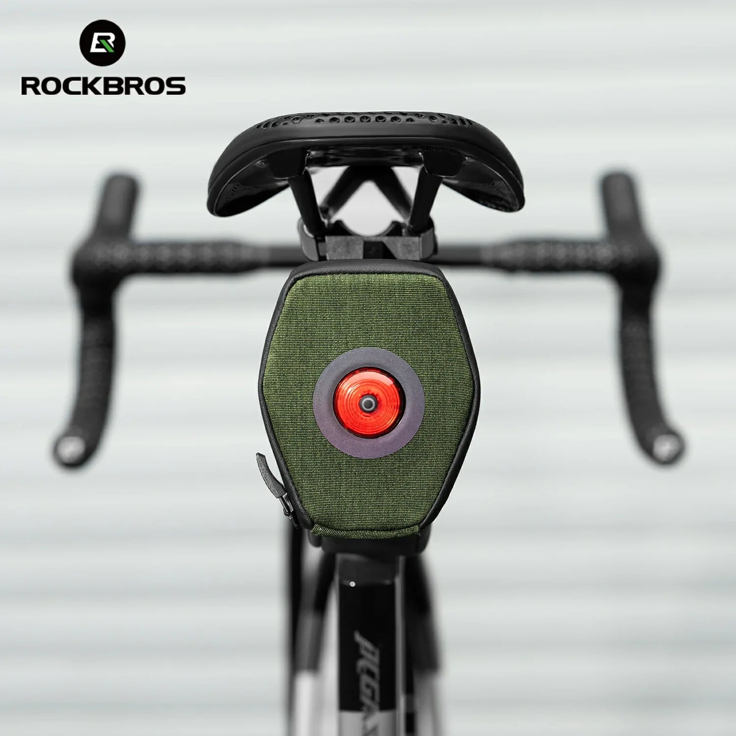 Close-up of a bicycle with a green light and red center, branded with RockBros. 