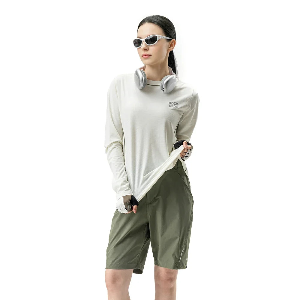 Person wearing a white long-sleeve shirt and green shorts on a white background