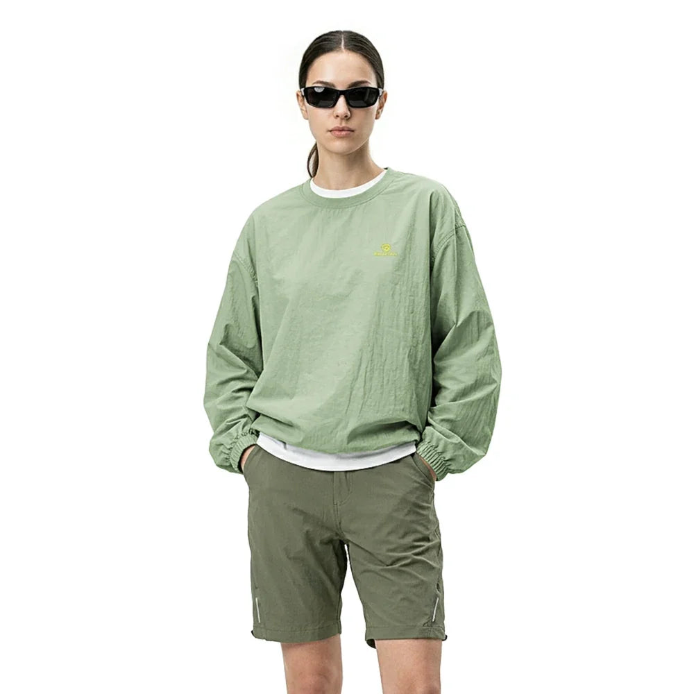 Person wearing a green sweatshirt and shorts on a white background