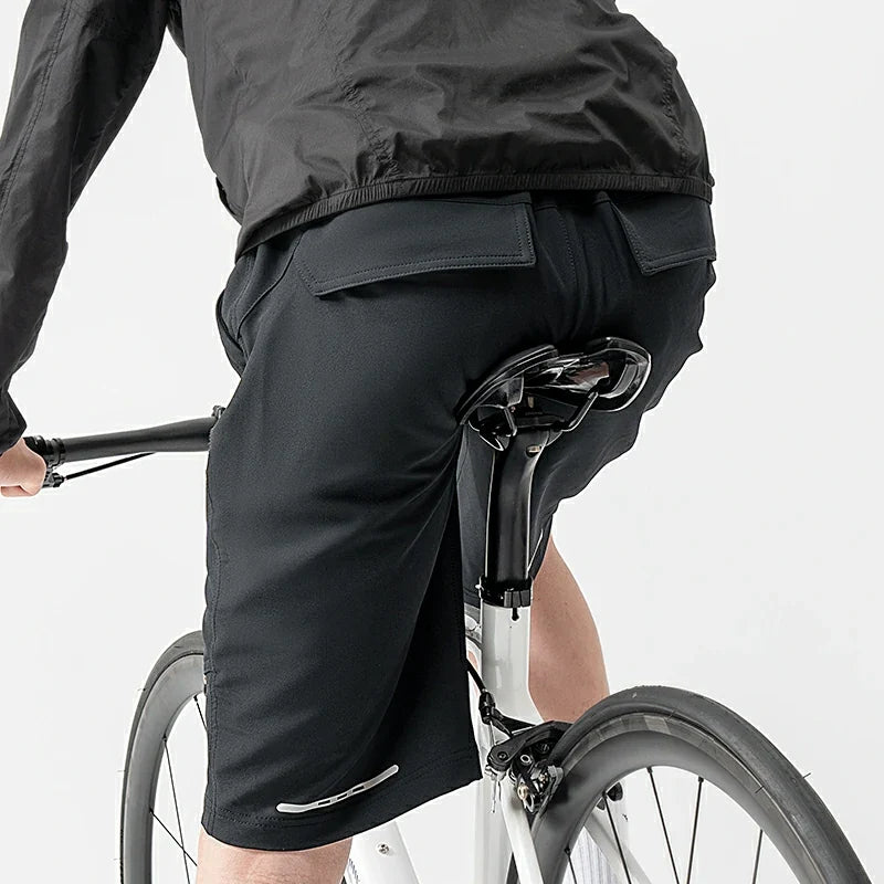 Person wearing black cycling shorts on a bicycle against a white background