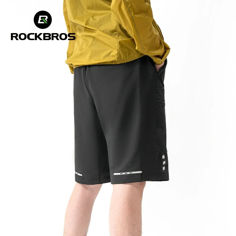 Person wearing black shorts with a yellow jacket, featuring the RockBros brand logo.