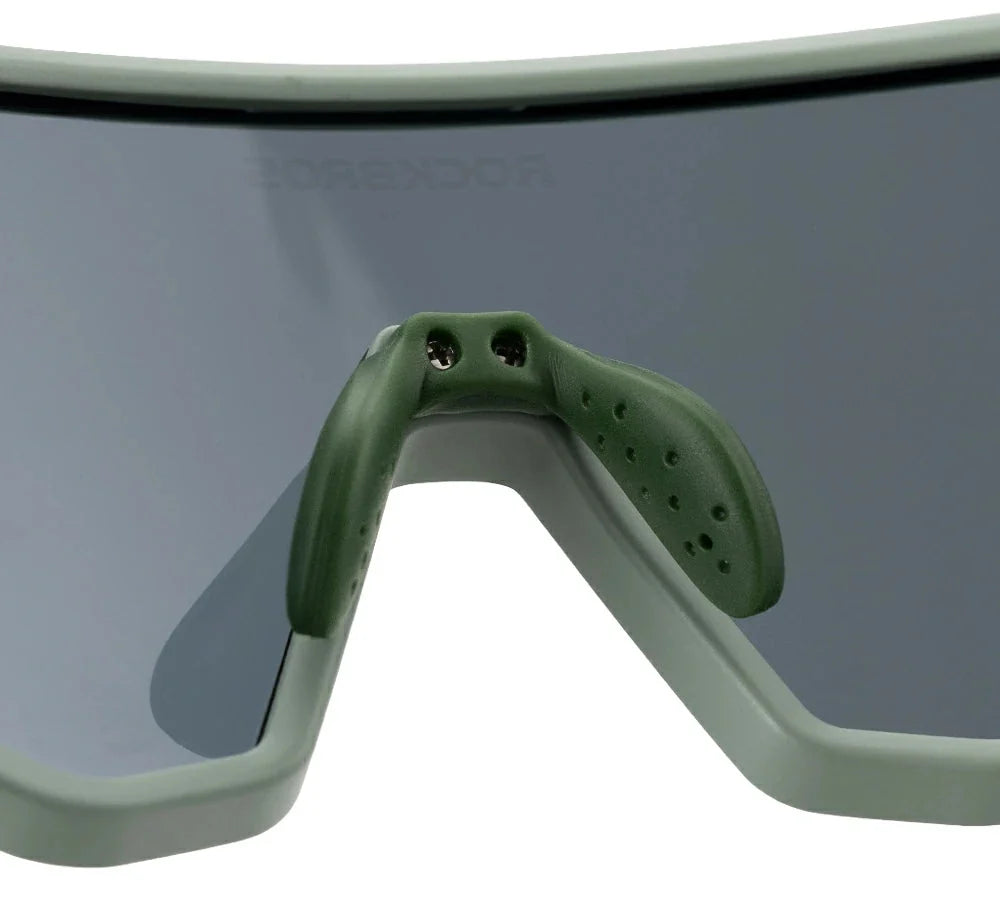 Close-up of a pair of goggles with a green frame and dark lenses on a white background.