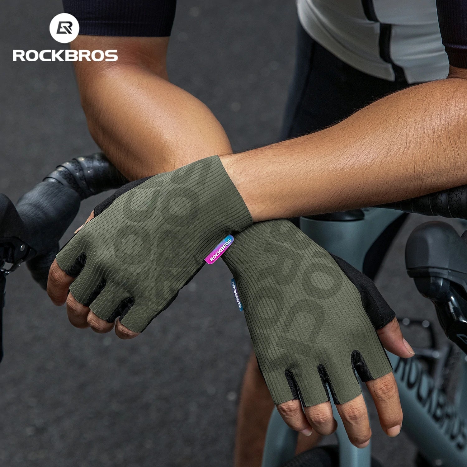 Person wearing green fingerless gloves with a visible brand logo, holding onto a bike. #color_Green