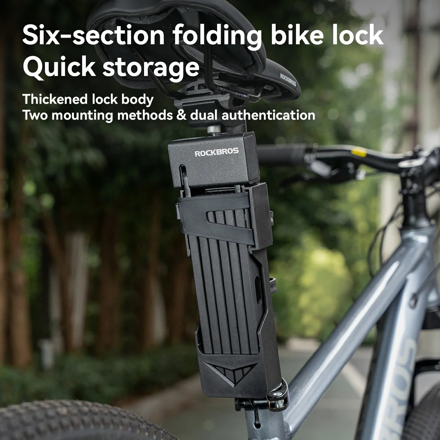 Six-section folding bike lock with mounting on a bicycle, surrounded by greenery.