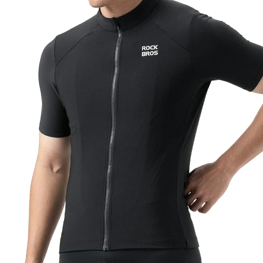 A close-up of a person wearing a black short-sleeve cycling jersey with a full front zipper and a white 'ROCK BROS' logo on the left chest, against a plain white background. #Color_Black