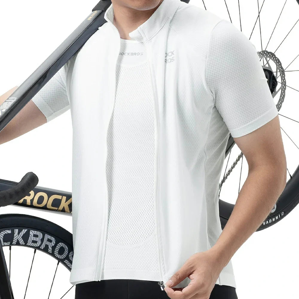 A close-up of a person wearing a white short-sleeve cycling jersey vest with a front zipper, shown against a white background with a bicycle wheel and handlebar visible. #Color_White
