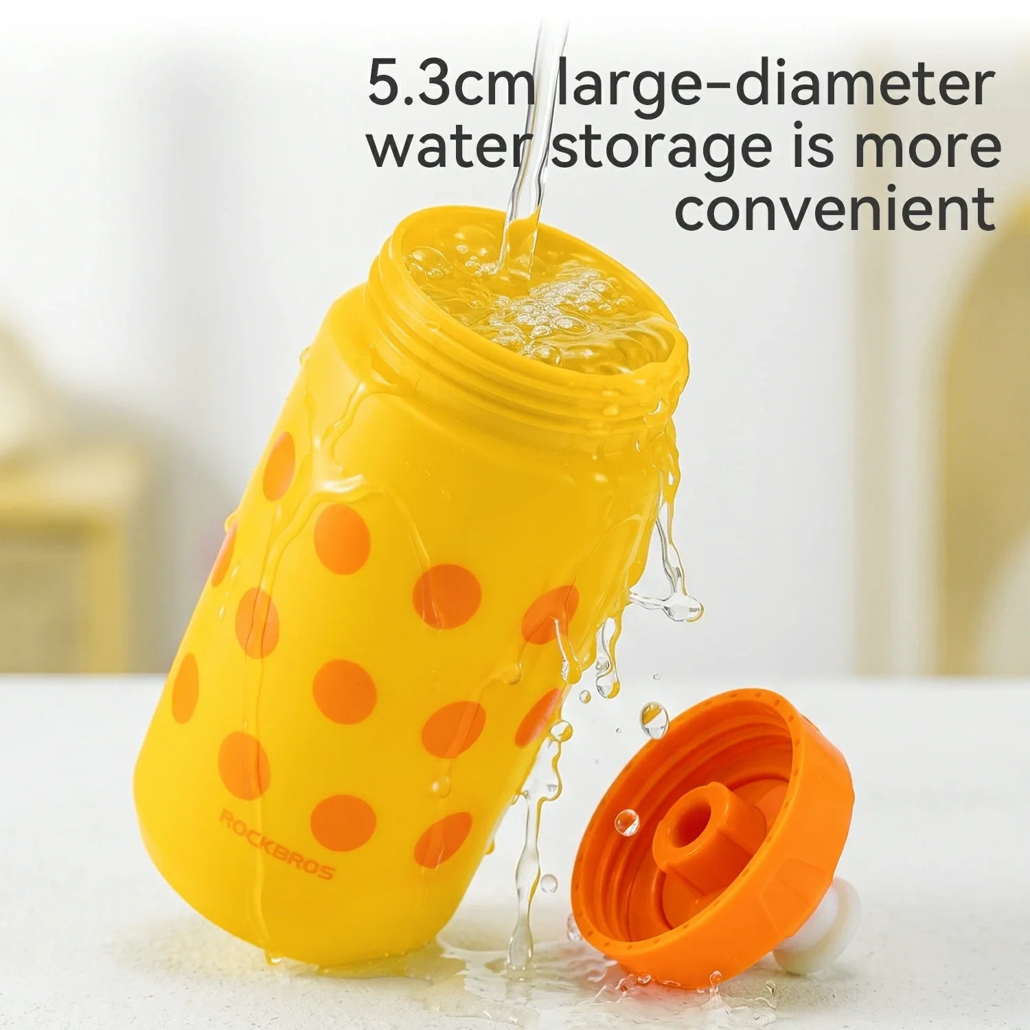 Yellow water bottle with orange polka dots and lid being filled with water on a white background