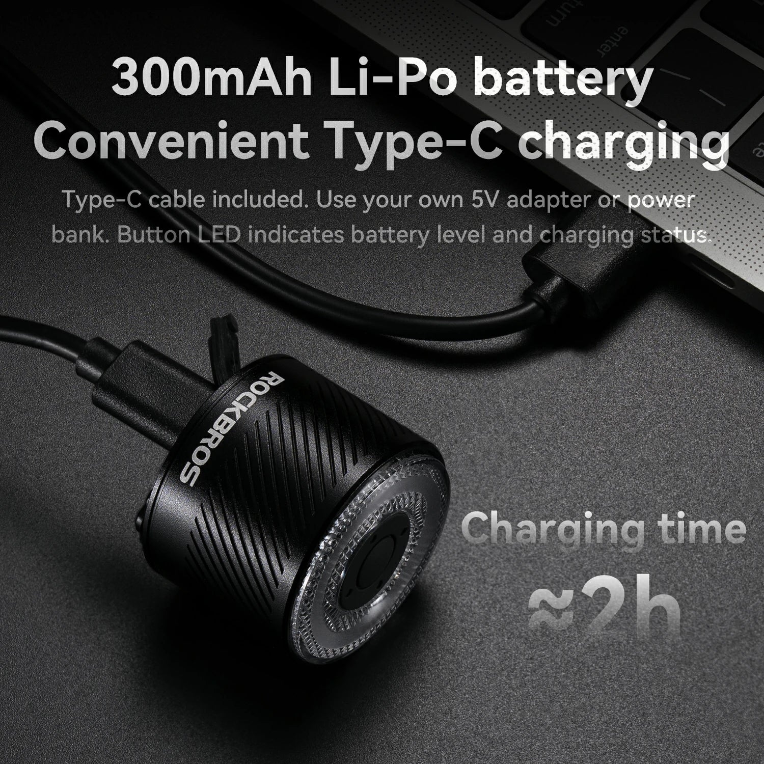 Black electronic device with charging cable on a dark background, featuring text about battery and charging details.