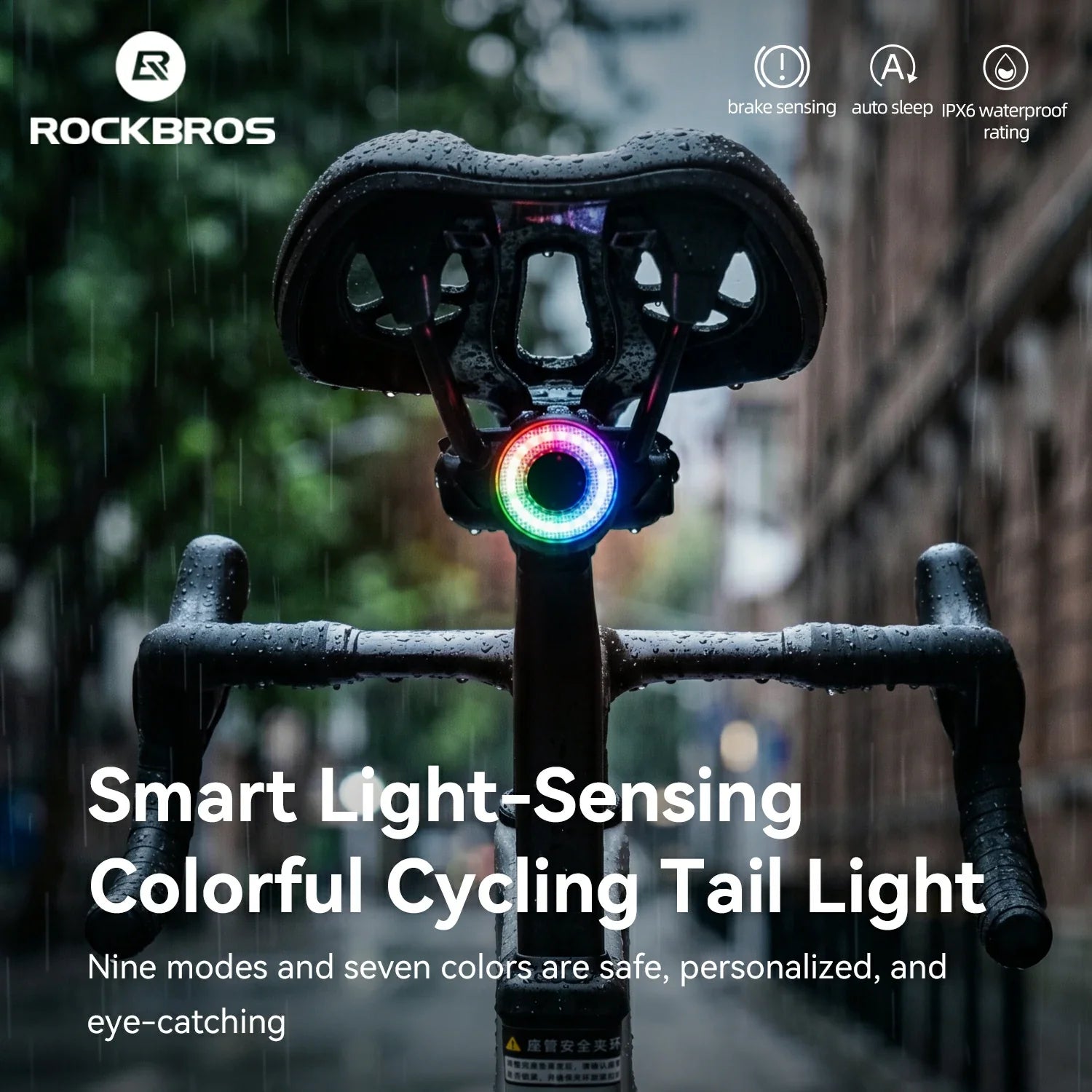 Bicycle tail light with colorful LED display on a blurred city street background, featuring RockBros branding.