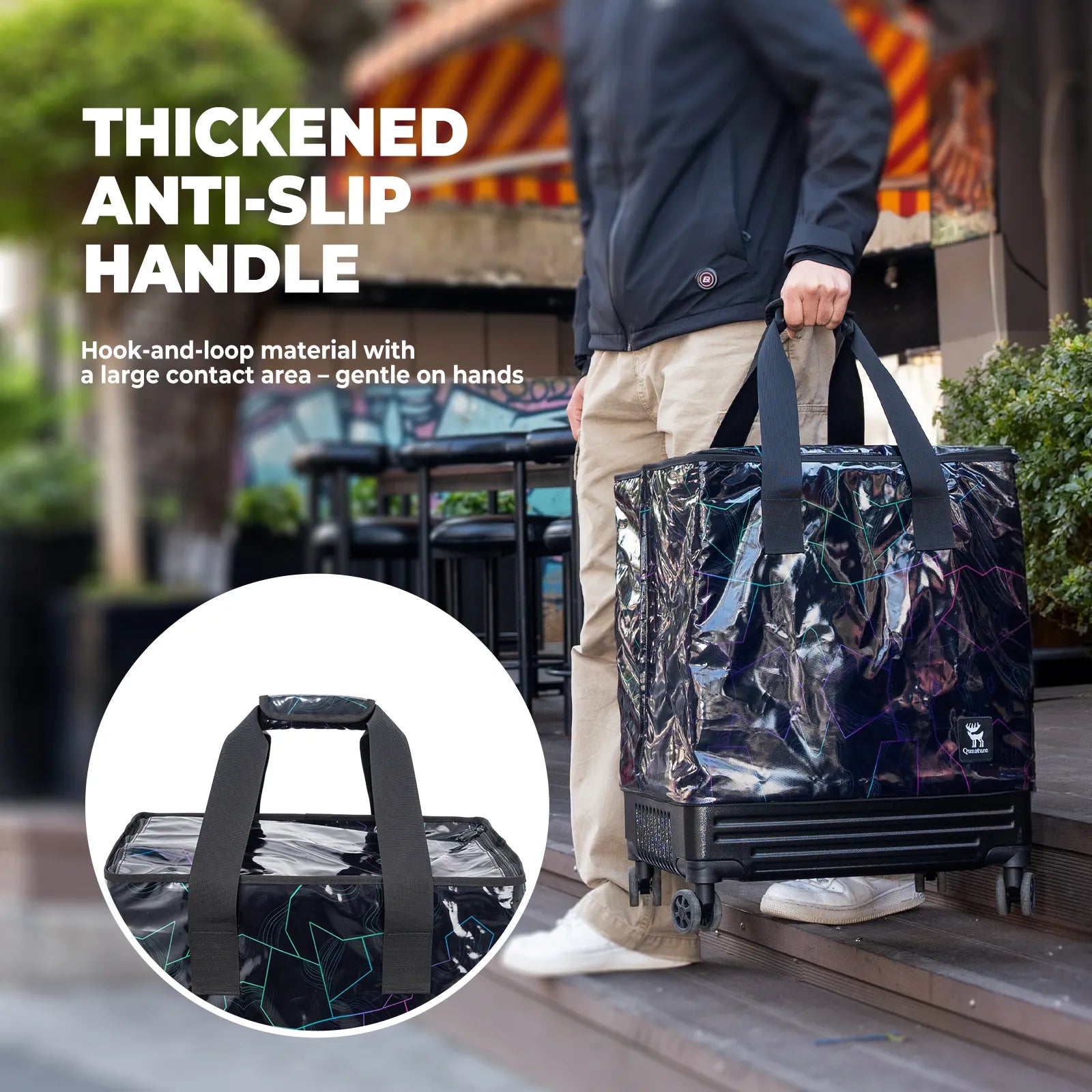 Person holding a large black bag with a thick anti-slip handle, outdoor setting.