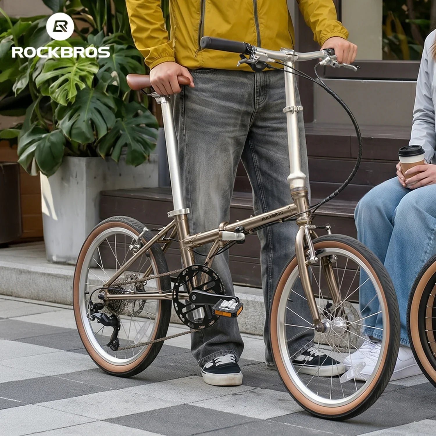Person holding a folding bicycle with 'RockBros' branding in the background.