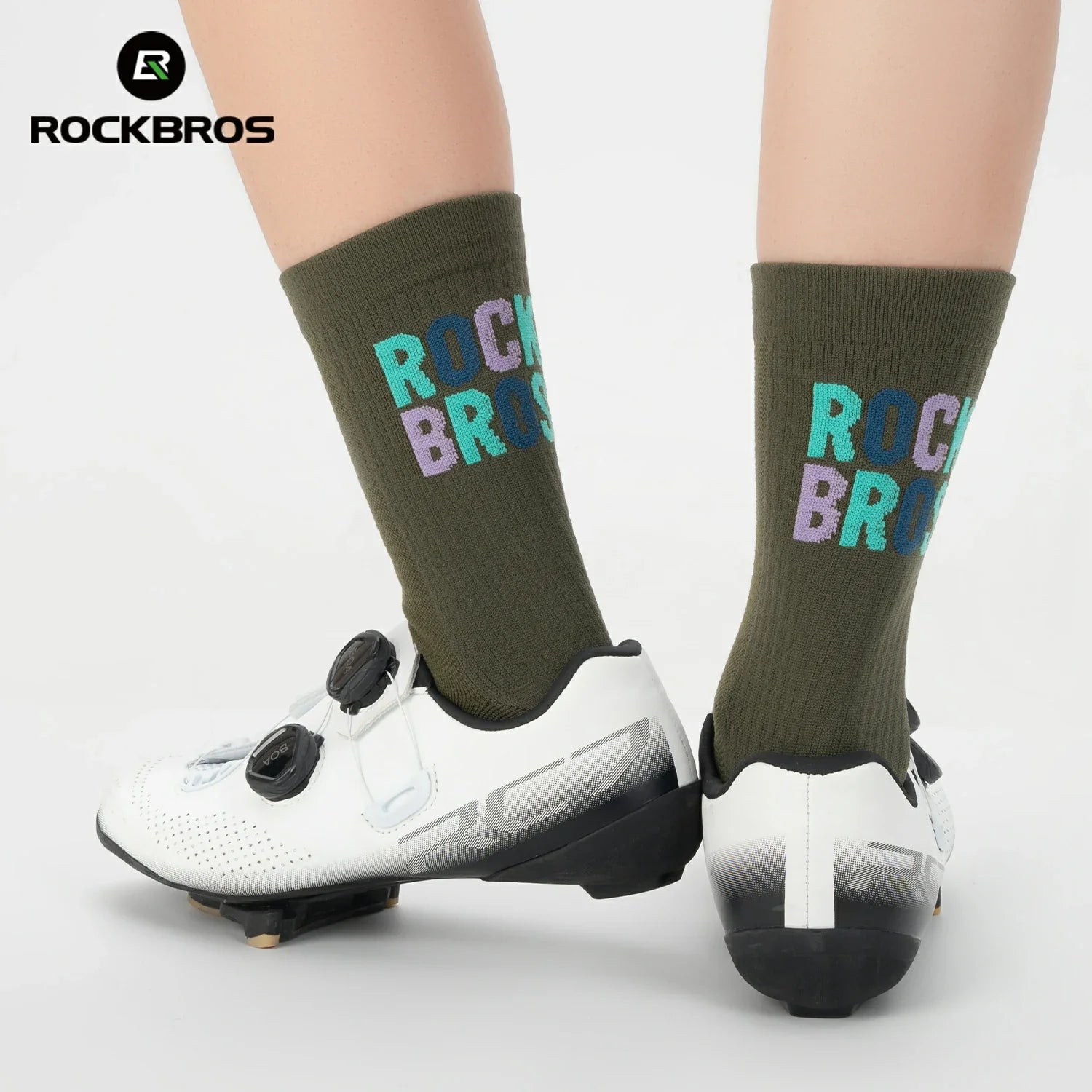 Person wearing green socks with 'RockBros' branding and white cycling shoes on a light gray background. #color_green