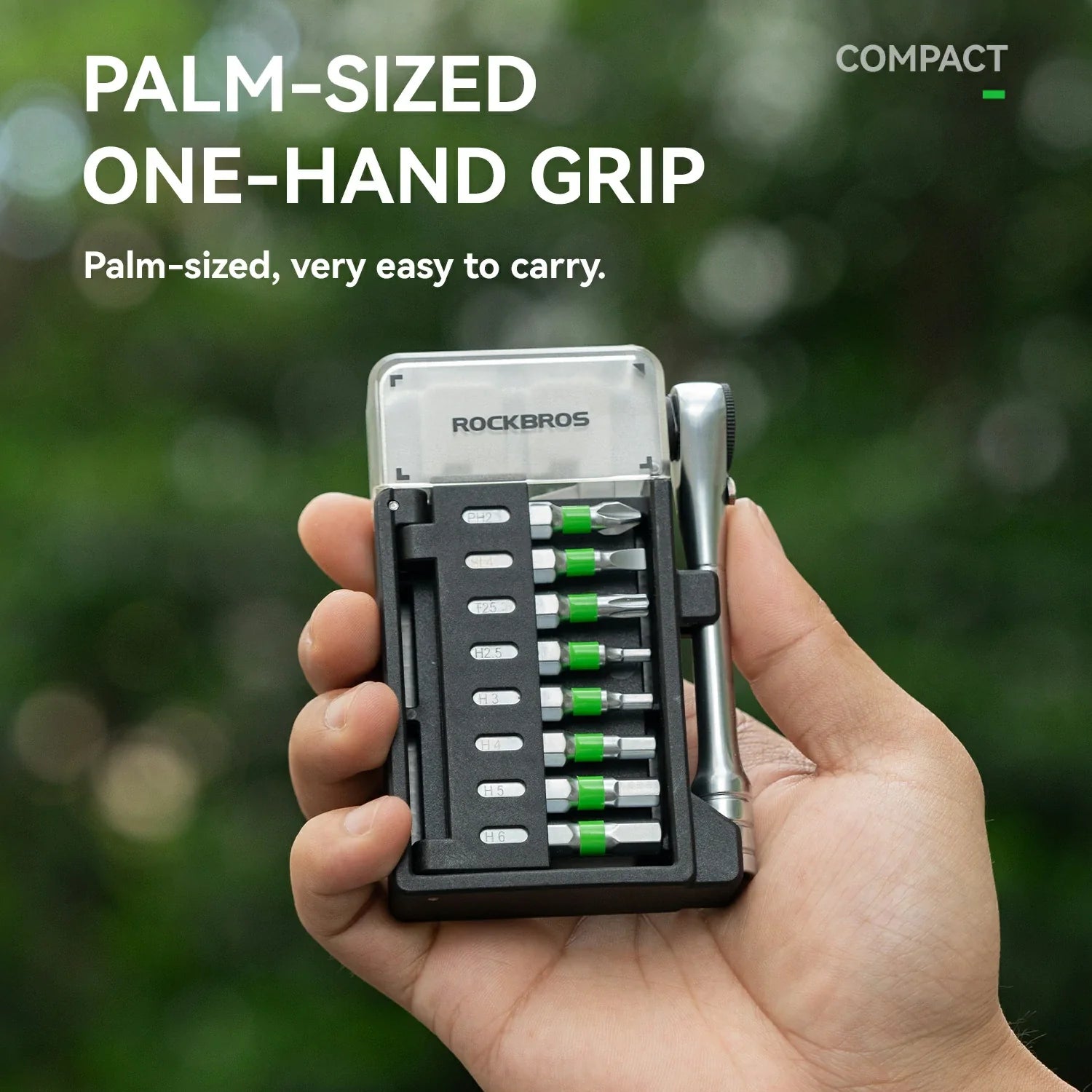 Compact tool set with screwdrivers held in a palm-sized case against a blurred green background