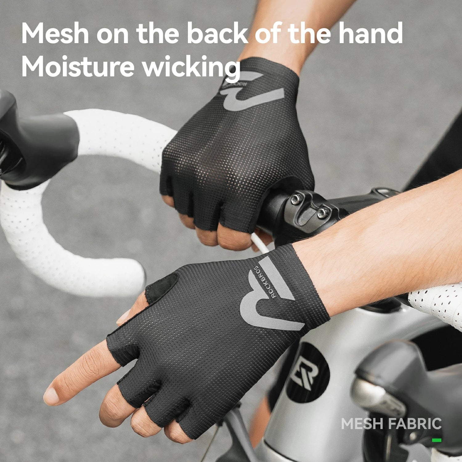 Person wearing black cycling gloves with text about mesh on the back of the hand and moisture wicking.