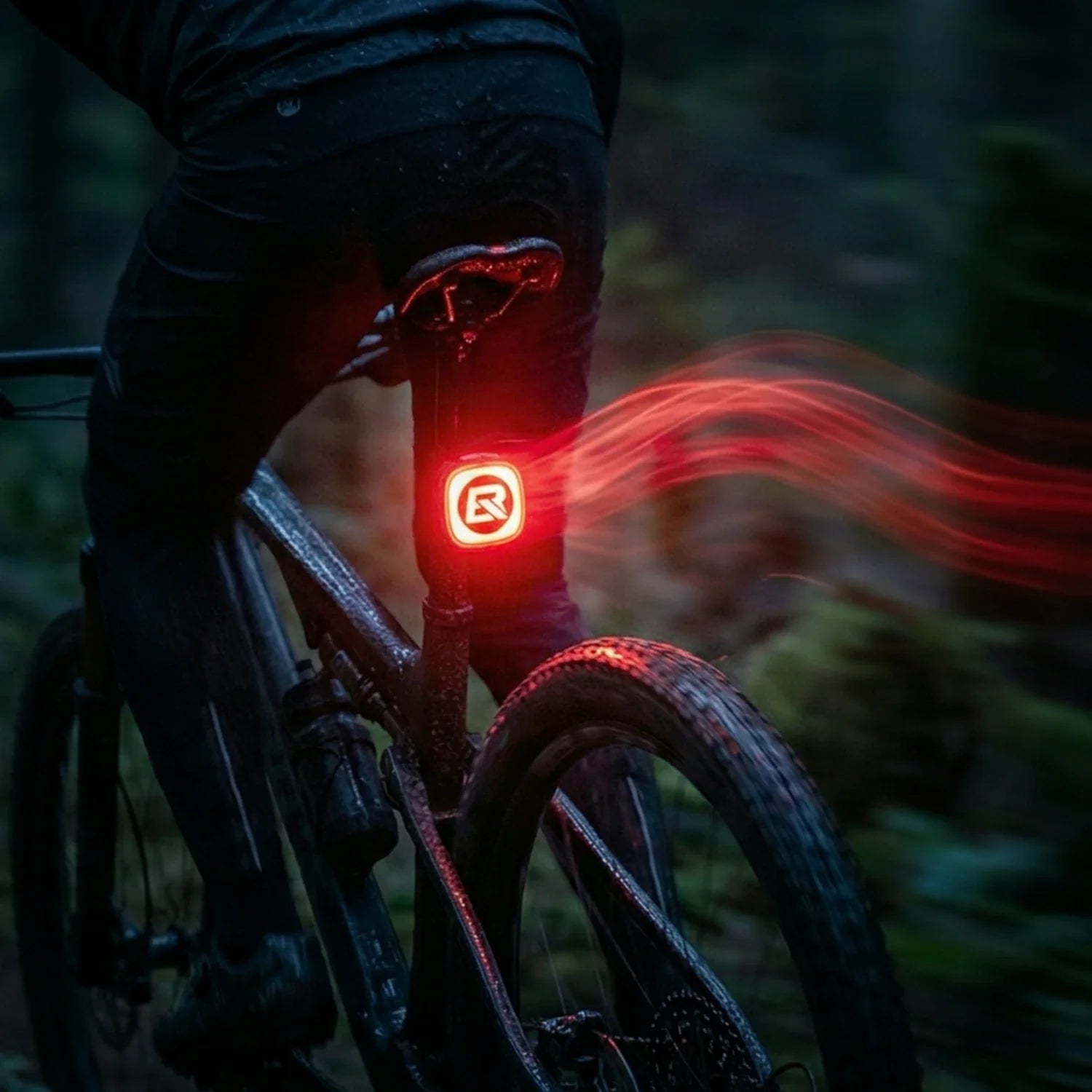 cyclist riding at night with the smart red taillight visible from behind