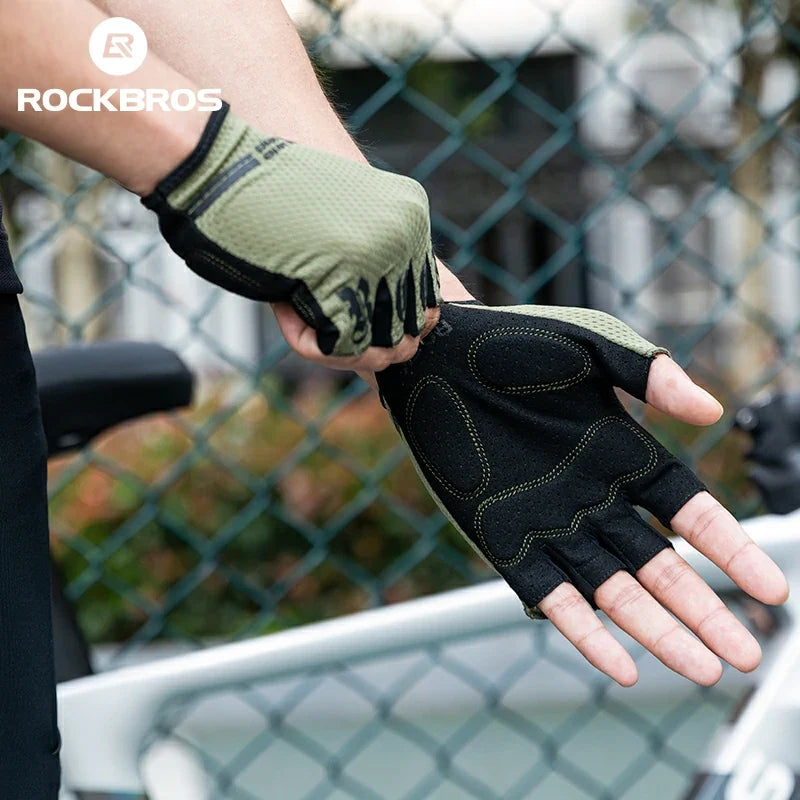 Person wearing a black and green half-finger glove with 'RockBros' branding. #color_green