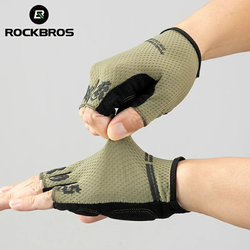 Person wearing a green half-finger glove with black accents, held up against a gray background, branded with RockBros. #color_green