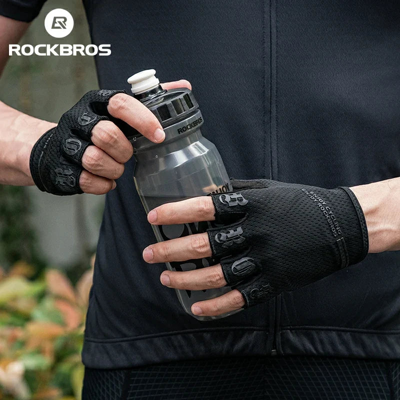 Person holding a water bottle with gloves on, wearing a black jacket with 'RockBros' branding.  #color_black