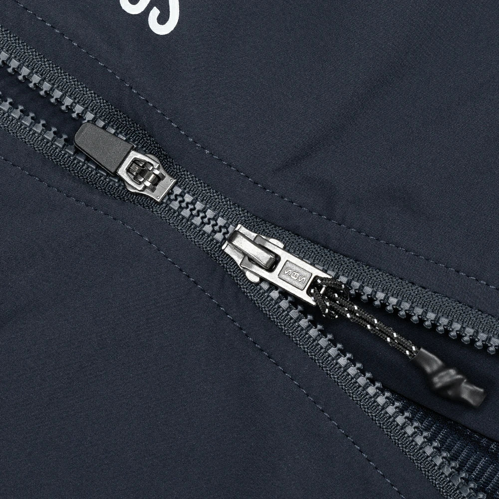Close-up of a zipper on a dark blue jacket with a brand logo.