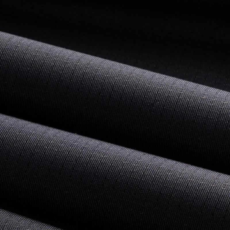 Close-up of black fabric with a subtle texture on a dark background #Color_Black