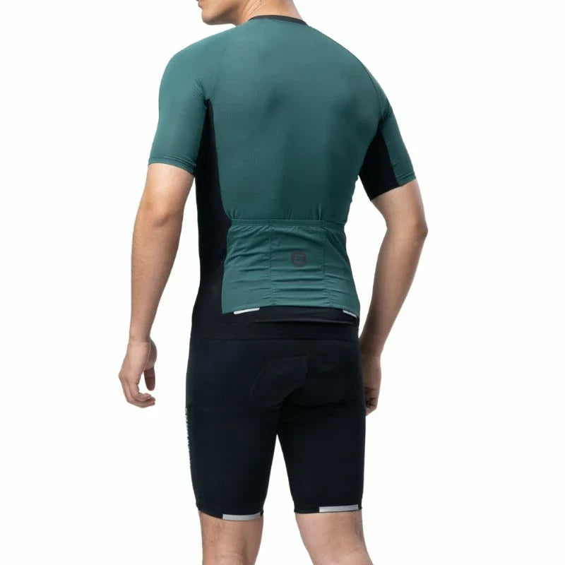 Person wearing a green cycling jersey and black shorts on a white background #Color_Green