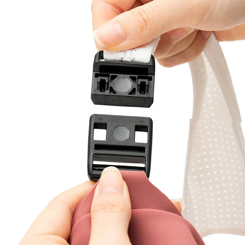 Person holding a black plastic component with a white label against a white background