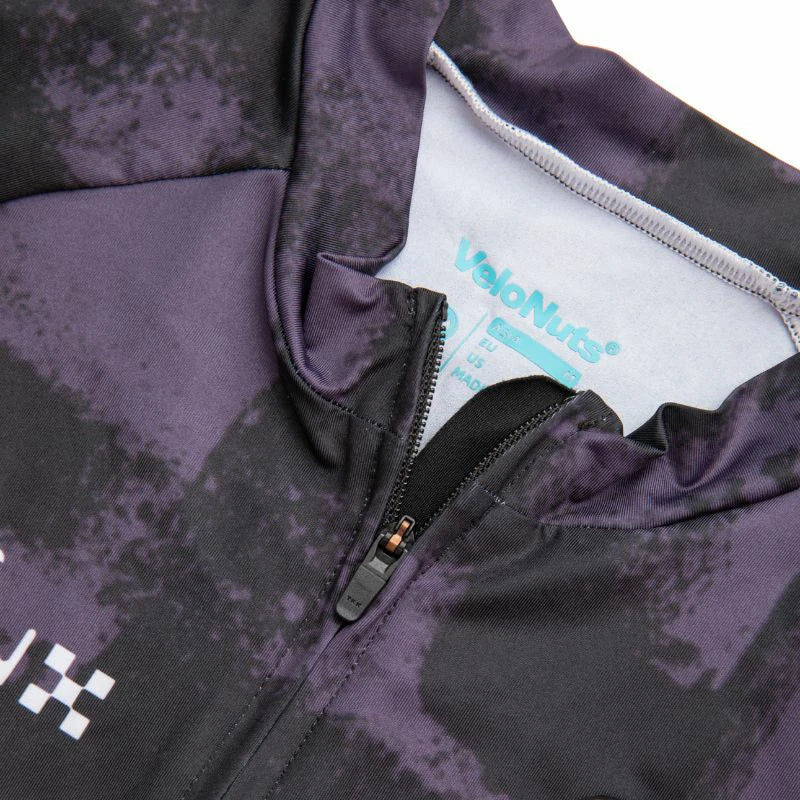 Close-up of a purple and black jacket with a brand label inside