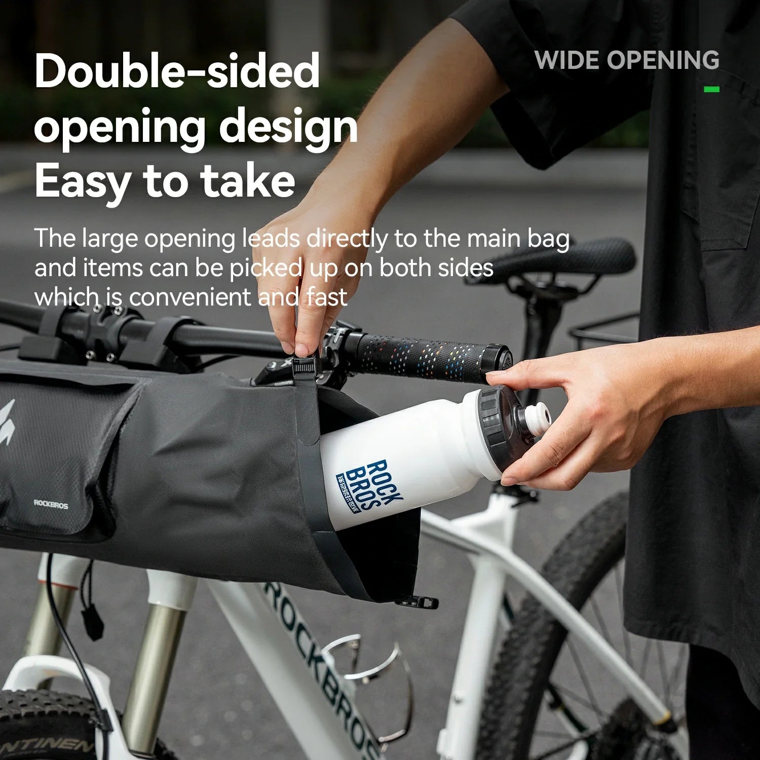 Person using a bike bag with a water bottle, highlighting its wide opening design.