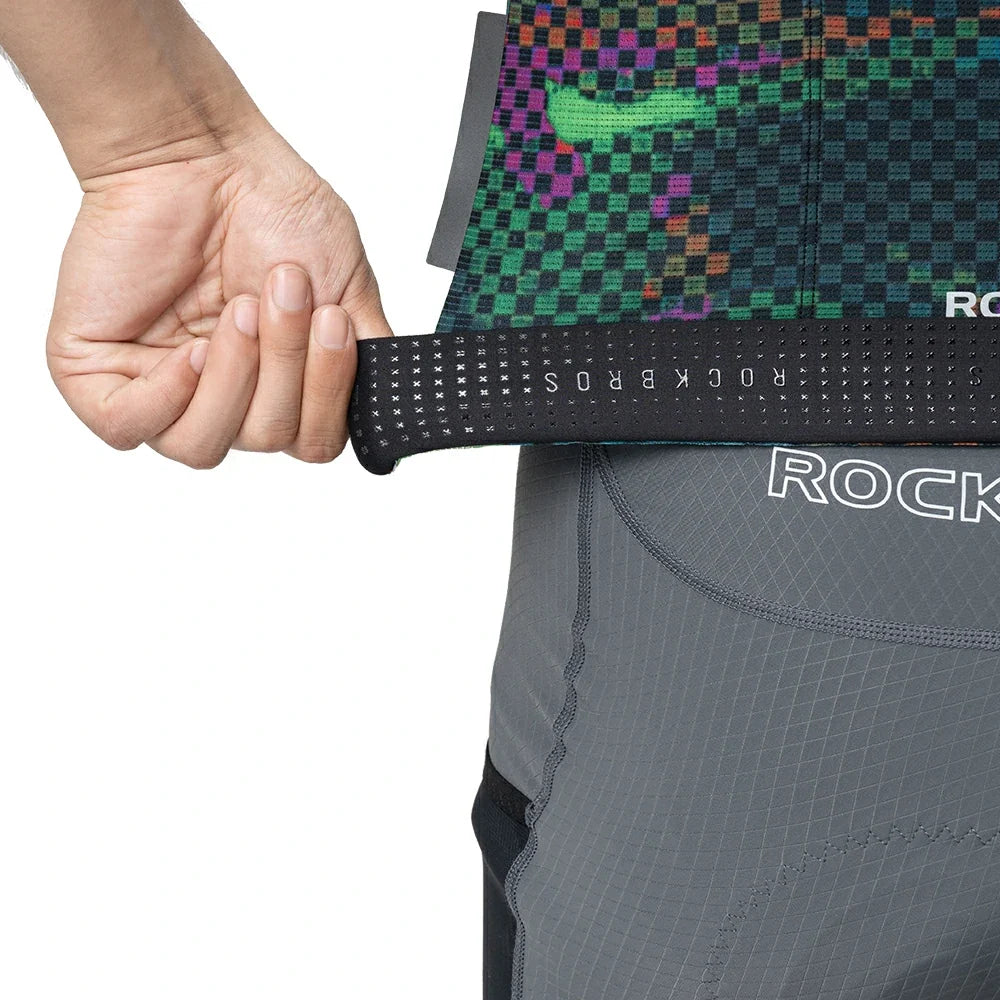 Person wearing a gray athletic outfit with a colorful patterned waistband, holding the waistband.