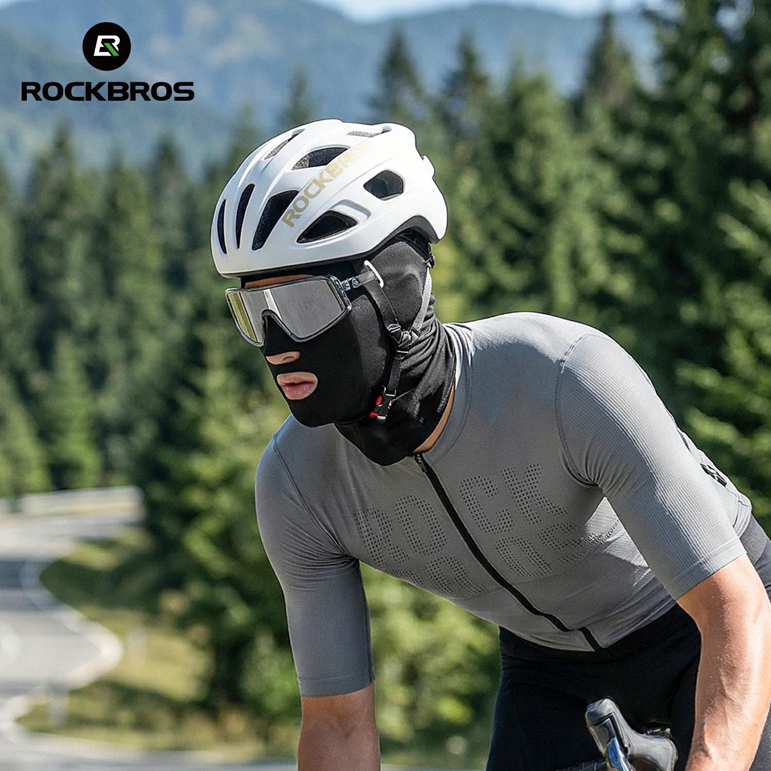 Person wearing a helmet and sunglasses with a mountainous background, featuring the RockBros brand.